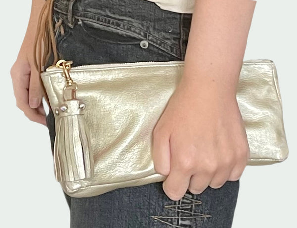 Gold leather clutch bag with leather tassel zipper pull trimmed in Swarovski crystals