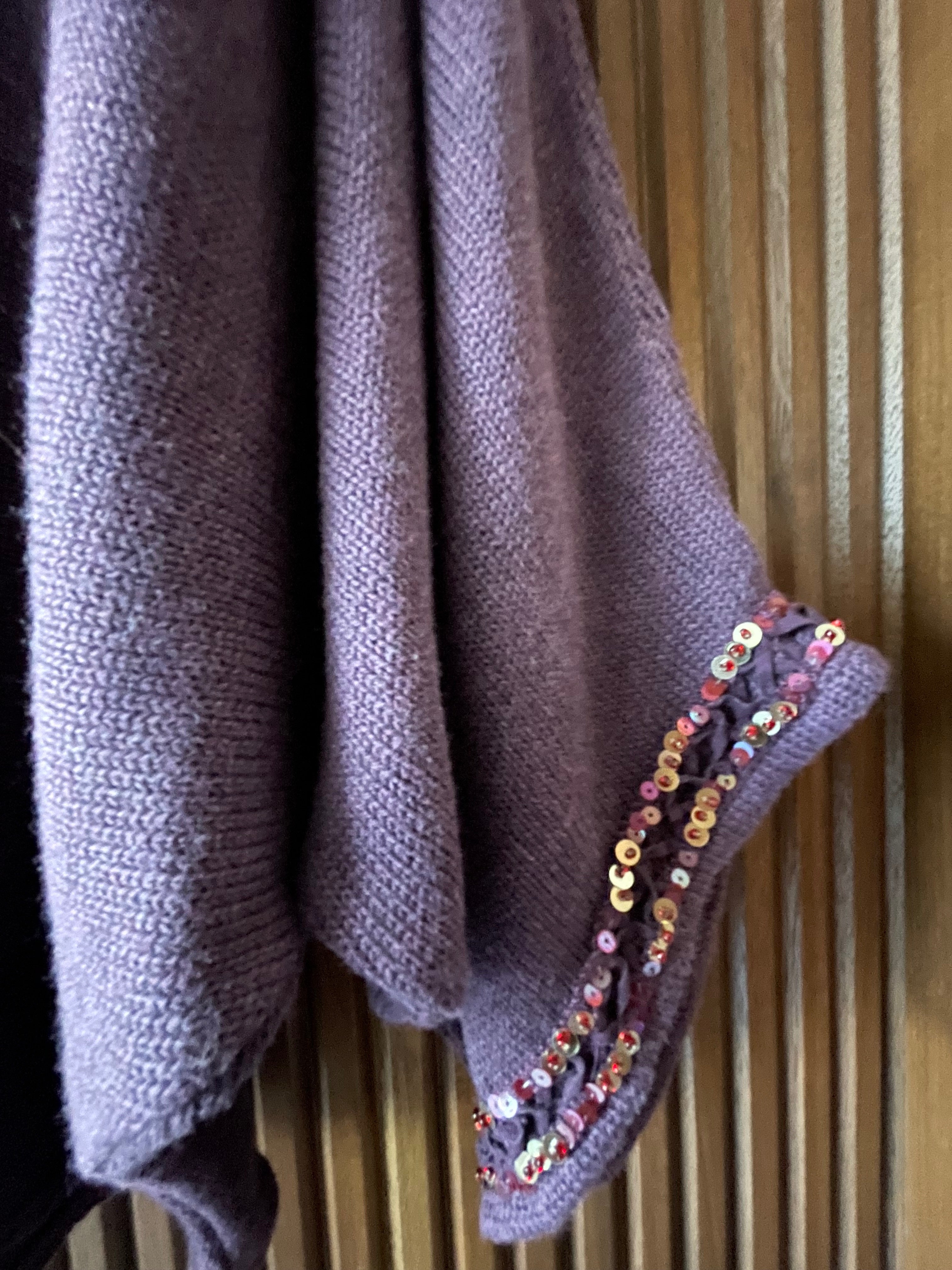 close up photo of sleeve detail on Spritz Sweater in mulberry color. Sleeve opening is hand beaded with two rows of vintage sequins and seed beads in gold, pink, red, and purple colors. 